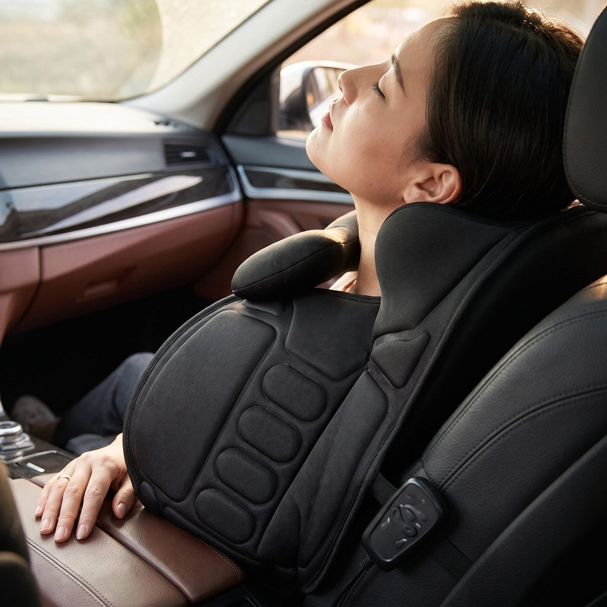 Persona rilassata contro il cuscino massaggiante shiatsu riscaldato in auto