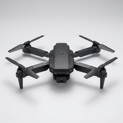 Mini drone con telecamera pieghevole nero in volo sopra un prato