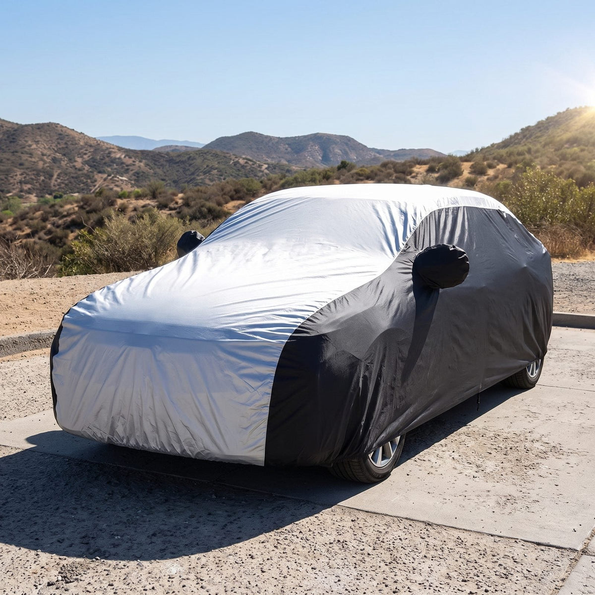 Auto coperta parcheggiata in pieno sole, la parte superiore argentata del telo riflette la luce