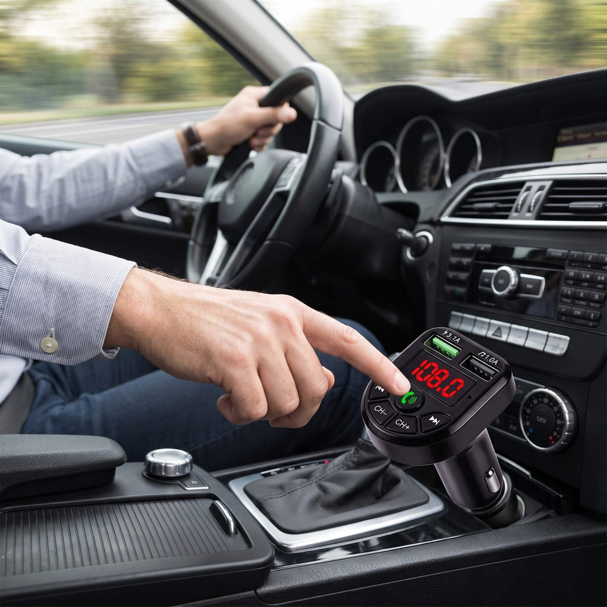 Guidatore che preme il pulsante verde vivavoce del trasmettitore FM Bluetooth