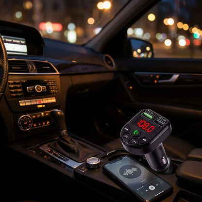 Trasmettitore FM Bluetooth acceso di notte in auto, schermo rosso visibile, telefono con la musica in riproduzione